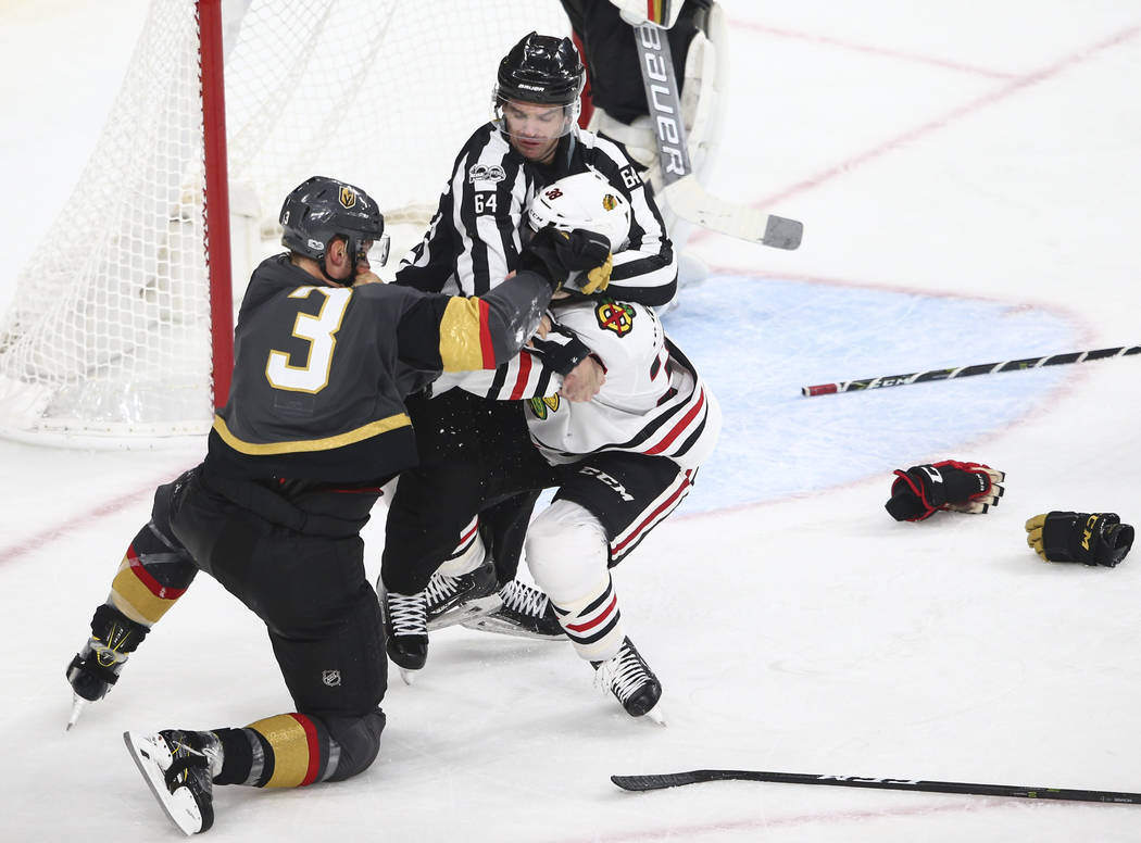 An official stops a fight between Golden Knights' Brayden McNabb (3) and Chicago Blackhawks' Ryan Hartman (38) during an NHL hockey game at T-Mobile Arena in Las Vegas on Tuesday, Oct. 24, 2017. C ...