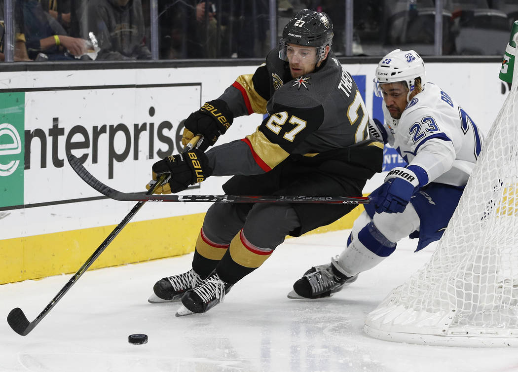 Vegas Golden Knights defenseman Shea Theodore, left, skates around Tampa Bay Lightning right wing J.T. Brown during the second period of an NHL hockey game Tuesday, Dec. 19, 2017, in Las Vegas. (A ...