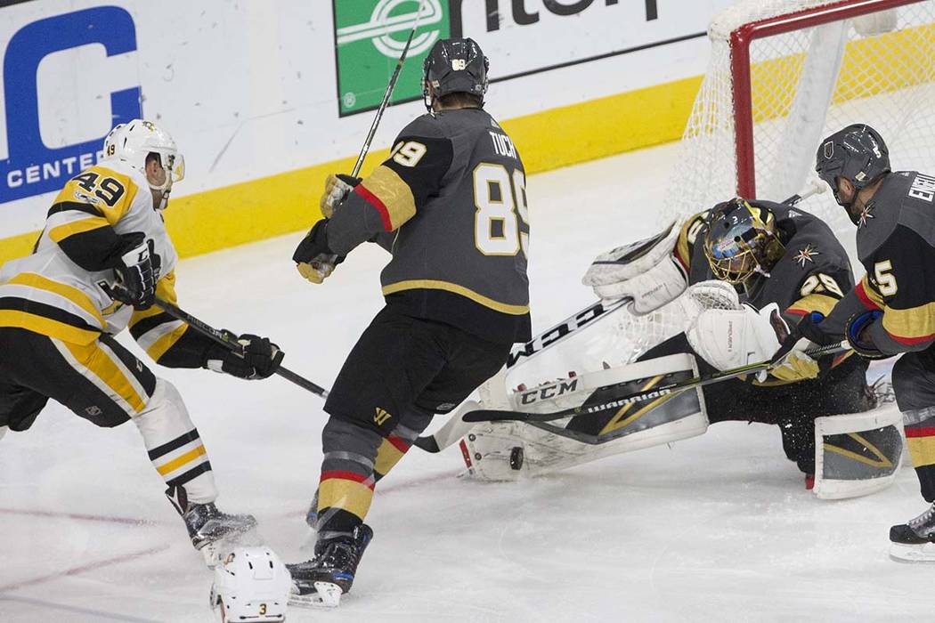 Golden Knights goaltender Marc-Andre Fleury (29) makes a save against Penguins center Dominik Simon (49) during the third period of Vegas' home matchup with Pittsburgh on Thursday, Dec. 14, 2017,  ...