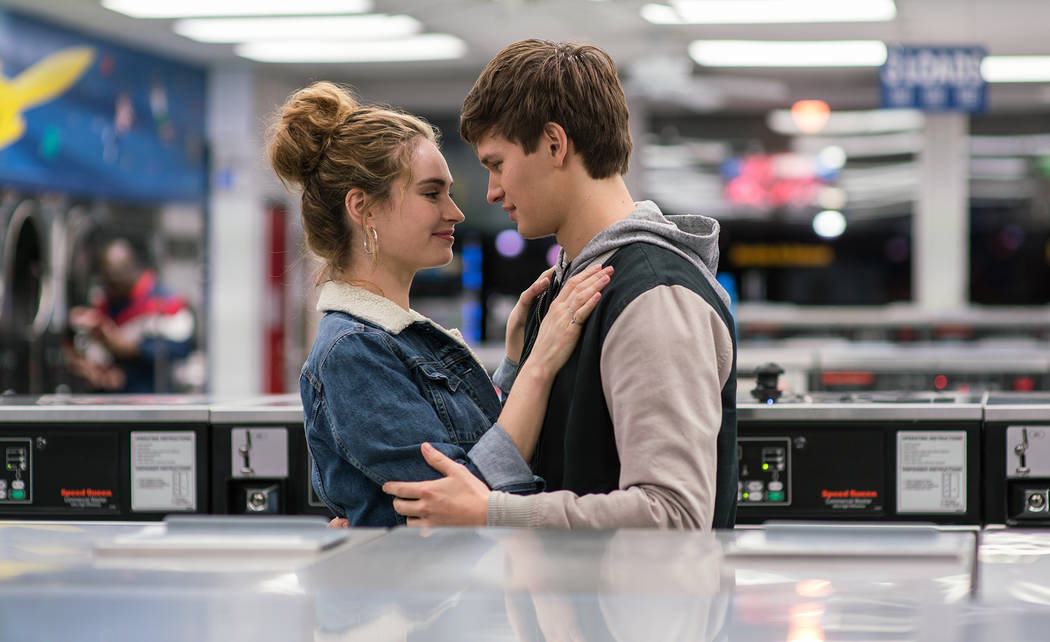 Baby (ANSEL ELGORT) helps Debora (LILY JAMES) do her laundry as they dance around each other and kiss in TriStar Pictures' BABY DRIVER.