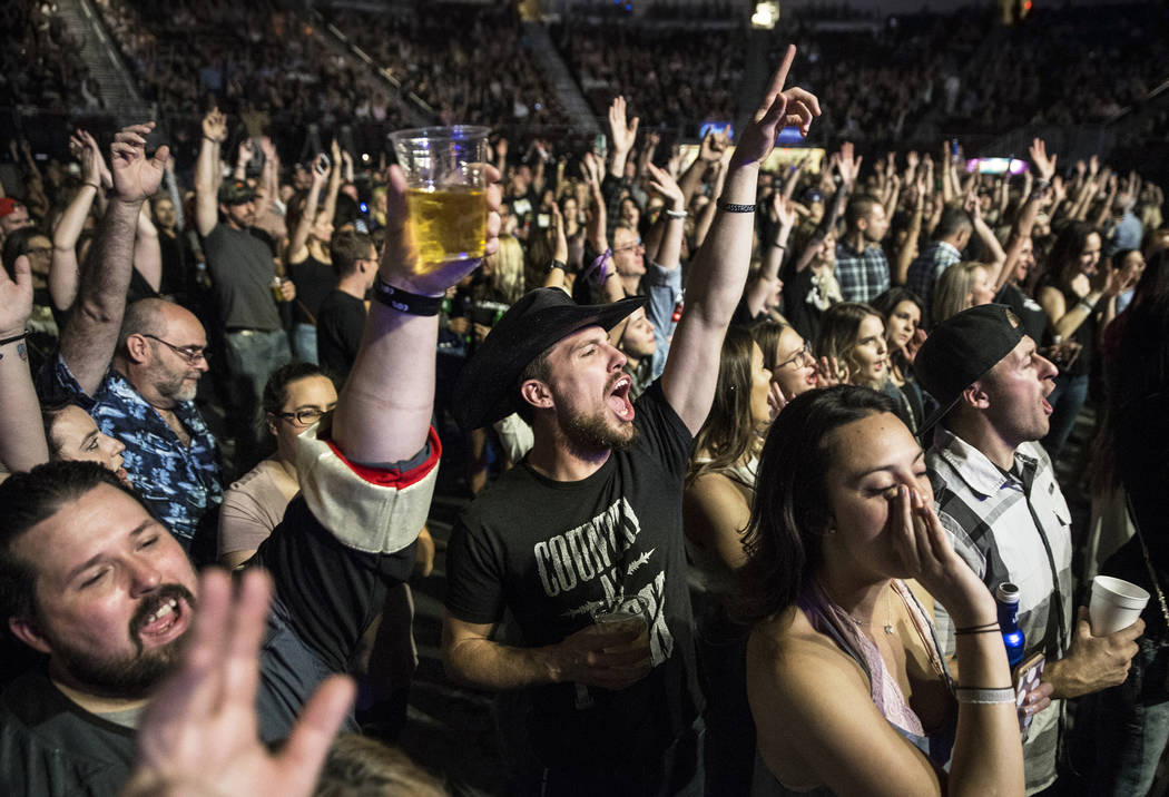 Jessie Patrick, middle, cheers for Big & Rich during 'Vegas Strong: A Night of Healing,' a benefit concert for first responders and those effected by the Route 91 shooting on Thursday, October ...