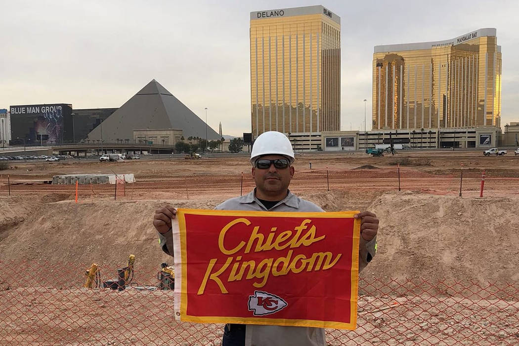 A Chiefs fan named Chris Scherzer posted a photo of a man wearing a white hardhat and dark glasses and holding a red and gold Chiefs banner with the inscription “Chiefs Kingdom” on his Faceboo ...