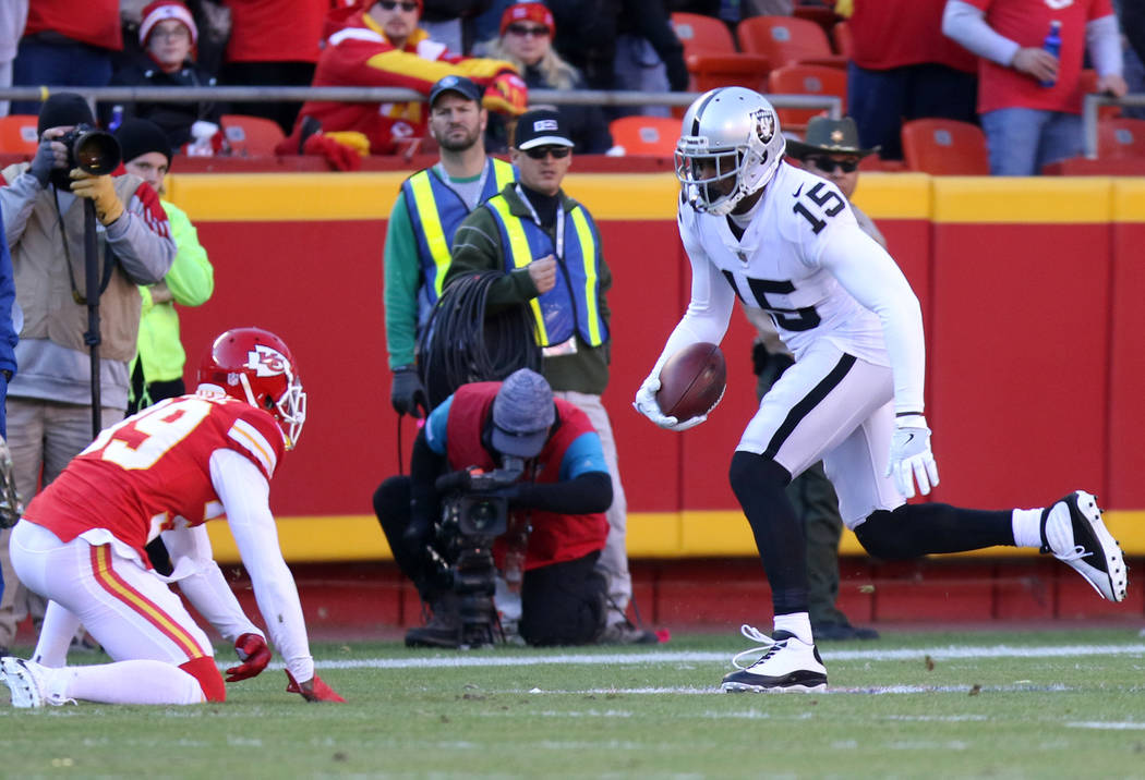 Oakland Raiders wide receiver Michael Crabtree (15) catches a pass as Kansas City Chiefs cornerback Terrance Mitchell (39) looks to tackle him during the first half of a NFL game in Kansas City, M ...