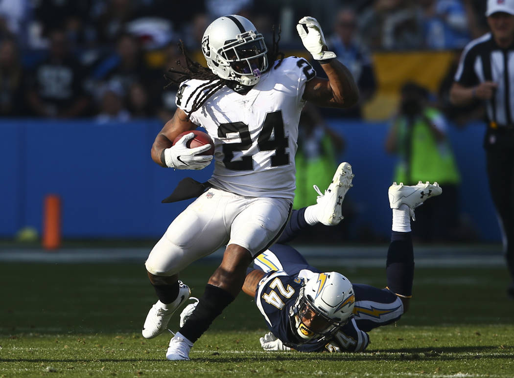 Oakland Raiders running back Marshawn Lynch, left, runs the ball past Los Angeles Chargers cornerback Trevor Williams (24) during an NFL game at StubHub Center in Carson, Calif. on Sunday, Dec. 31 ...