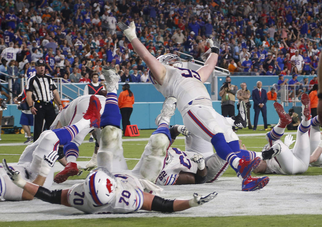 Buffalo Bills defensive tackle Kyle Williams (95) and a group of players fall to the ground in celebration after Williams scored a touchdown, during the second half of an NFL football game against ...