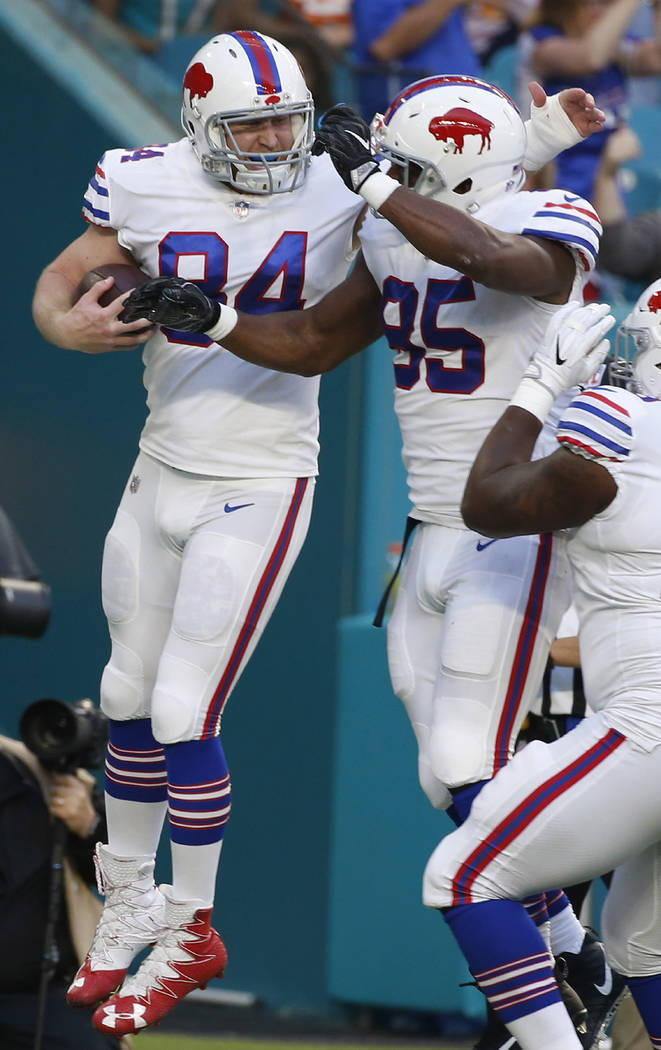 Buffalo Bills defensive tackle Kyle Williams (95) congratulates tight end Nick O'Leary (84), after O'Leary scored a touchdown, during the first half of an NFL football game against the Miami Dolph ...