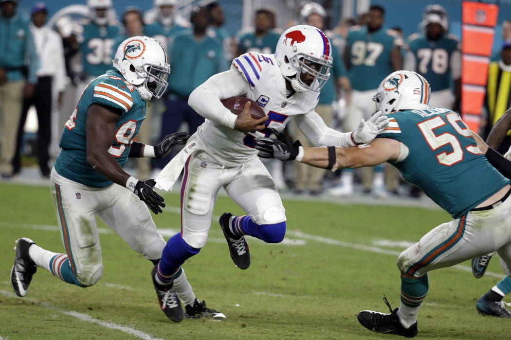 Miami Dolphins outside linebacker Lawrence Timmons (94) and outside linebacker Chase Allen (59) attempt to tackle Buffalo Bills quarterback Tyrod Taylor (5), during the second half of an NFL footb ...