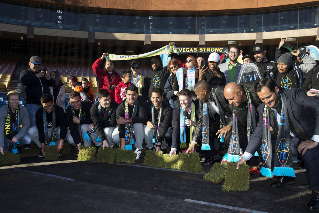 People, including players, coaches and digntitaries attend a Las Vegas Lights FC event to lay the first pieces of turf at Cashman Field to help transition the stadium from a baseball to a soccer v ...