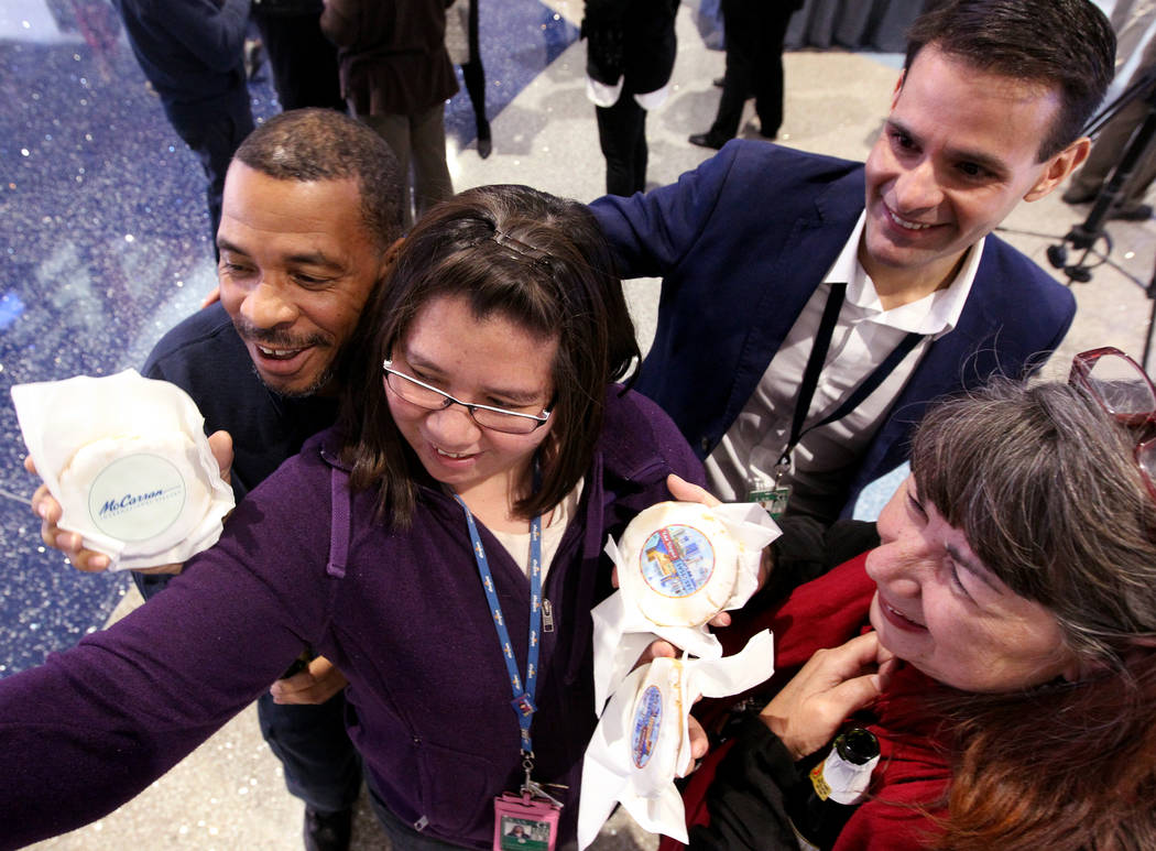 Employees, from left, Alonzo Ledford, Lorraine Kae Cruz, Jay Alvarez and Caryn Hatalla pose for a selfie with decorative cookies at McCarran International Airport during a celebration Wednesday, J ...