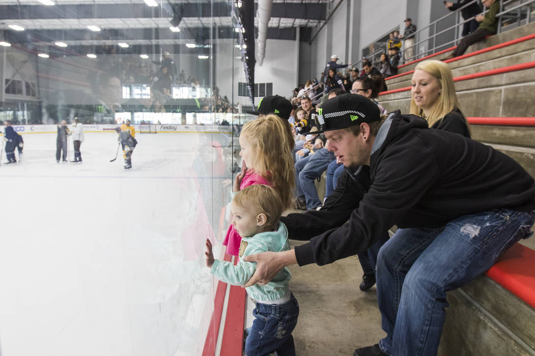 Andrew Alderman holds his daughter Rilyn Adlerman, 19 months, as they watch the Vegas Golden Knights practice alongside his wife Holly Alderman and daughters Adeline Alderman, 3, and Madison Alder ...