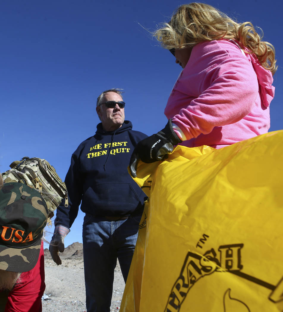 Interior Secretary Ryan Zinke talks with Cheryl Prater, right, while joining volunteers in cleaning up a shooting range area on public land along Las Vegas Boulevard just south of Sloan on Friday, ...