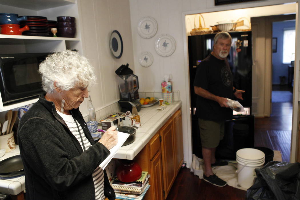 Pamela Arneson writes down the food that was lost as Eric Arneson, 72, cleans out the refrigerator after returning to their home for the first time in almost two weeks in Montecito, Calif., Thursd ...