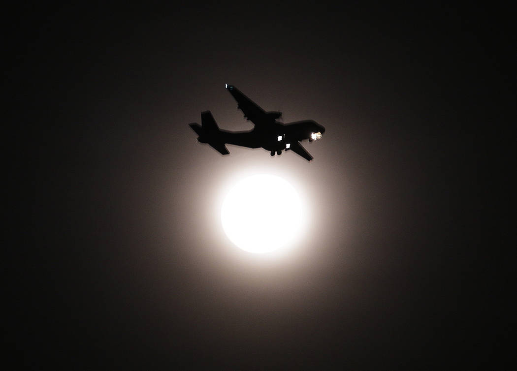 An airplane passes the full moon on its final approach before landing in Seoul, South Korea, Wednesday, Jan. 31, 2018. The moon is putting on a rare cosmic show. It's the first time in 35 years a  ...