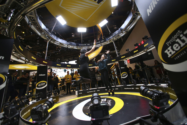 Attendees jump for a photo at the Nikon booth during CES at the Las Vegas Convention Center in Las Vegas on Friday, Jan. 6, 2017. (Chase Stevens/Las Vegas Review-Journal) @csstevensphoto