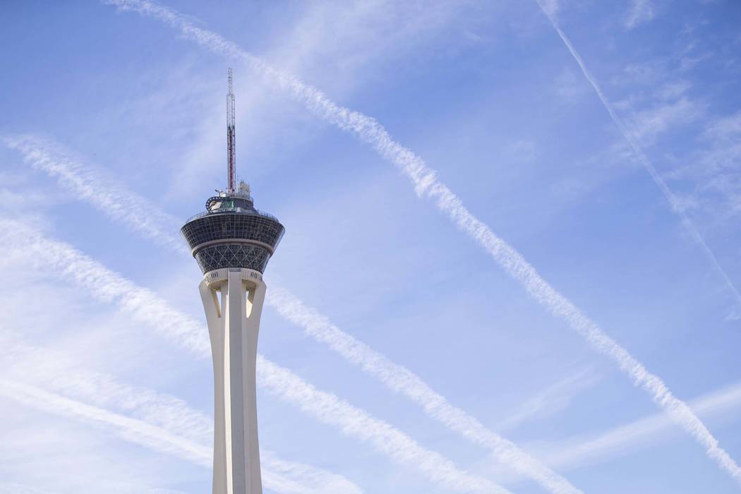 Vapor trails left behind by airplanes are seen above the Stratosphere tower in Las Vegas. (Richard Brian/Las Vegas Review-Journal) @vegasphotograph
