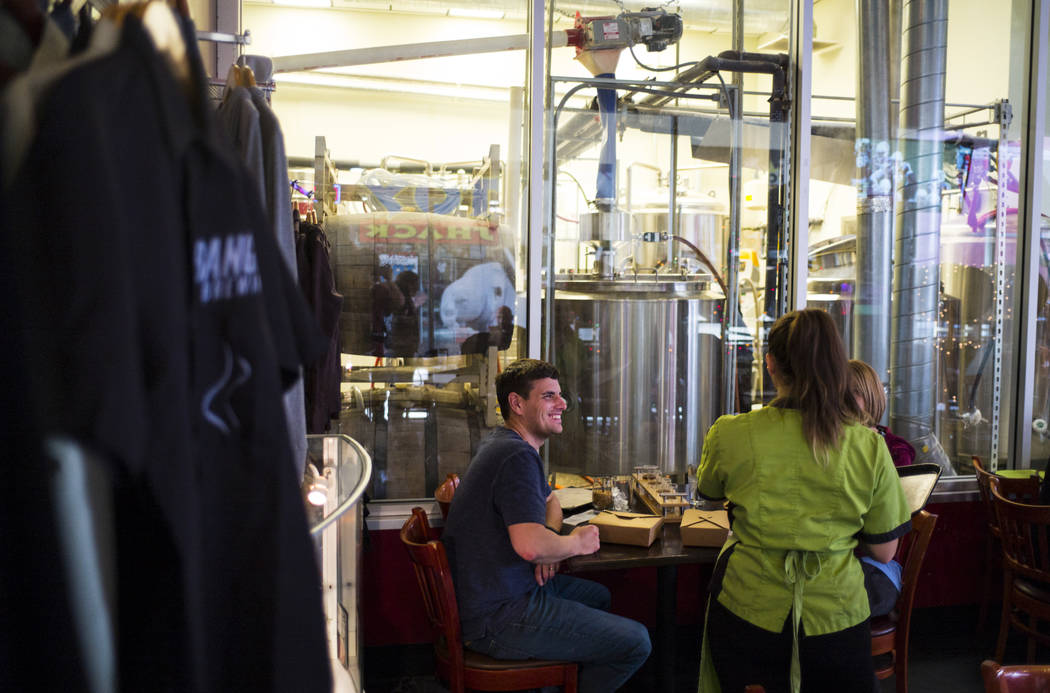 Sous chef Jaimie Fisher of Food Junky delivers food to Scott and Julie Jackson of Mason City, Ill. at Banger Brewing in downtown Las Vegas on Friday, Dec. 29, 2017. Food Junky, which recently bega ...