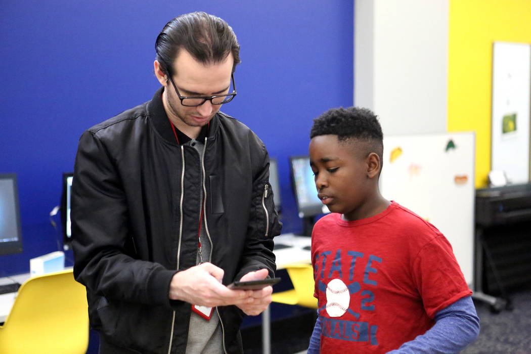 Teen Service Specialist Jake Duncan, 25, assists Frank Williamson, 13, with a mobile device app at the Clark County Library’s Teen Tech Center which gives kids access to high-tech electroni ...