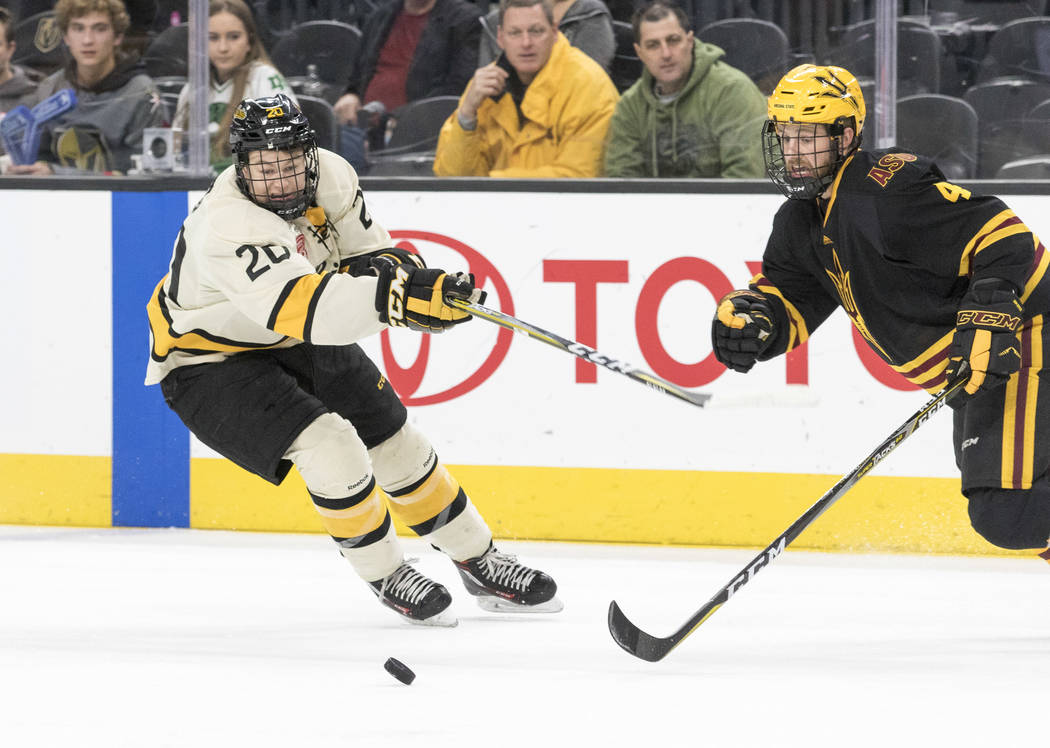 Michigan Tech Huskies forward Alex Smith (20) and Arizona State Sun Devils defenseman Jacob Wilson (4) chase the puck during the inaugural Ice Vegas Invitational college hockey tournament at T-Mob ...