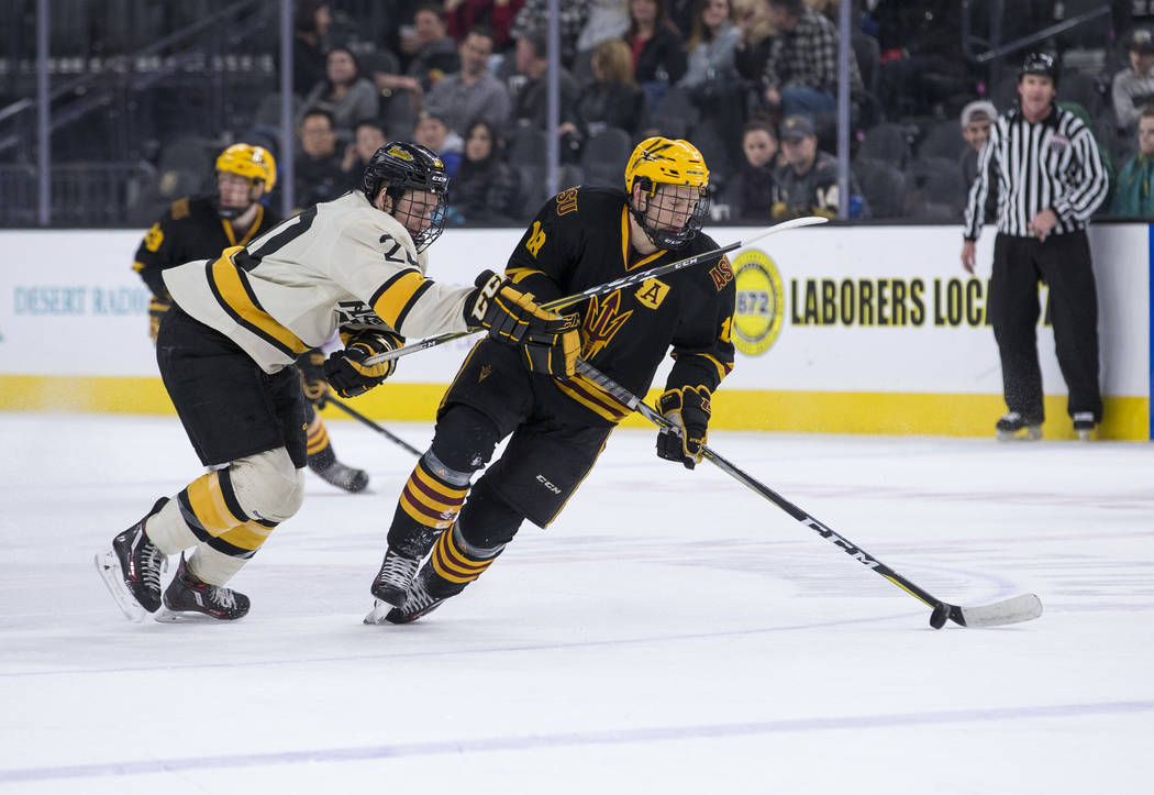 Arizona State Sun Devils forward Anthony Croston (18) controls the puck as Michigan Tech Huskies forward Alex Smith (20) defends during the inaugural Ice Vegas Invitational college hockey tourname ...