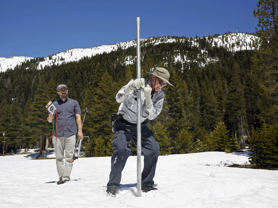 File - In this May 1, 2017 file photo, Frank Gehrke, chief of the California Cooperative Snow Surveys Program for the Department of Water Resources, right, plunges the snow survey tube into the sn ...