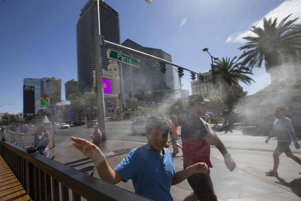 Pedestrians cool off on water misters along Las Vegas Boulevard in Las Vegas on Thursday, May 25, 2017. (Richard Brian/Las Vegas Review-Journal) @vegasphotograph