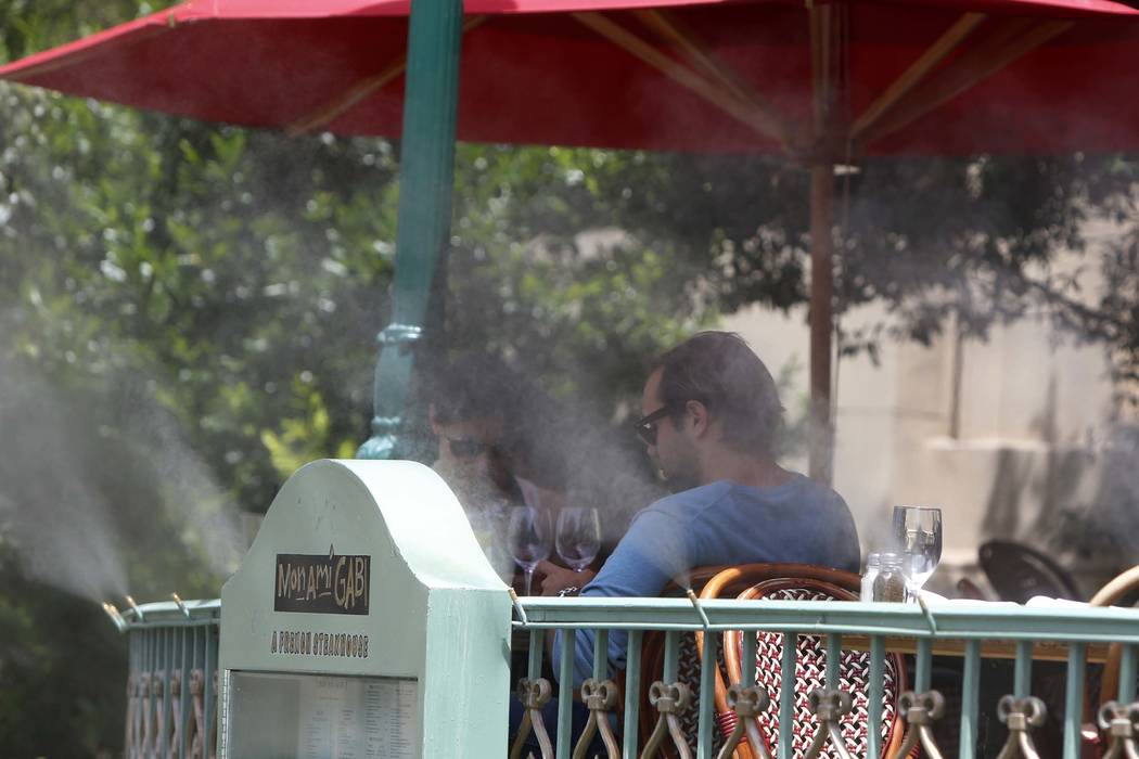 Tourists are seen on a hot day through misters as they sit outside Mon Ami Gabi restaurant at Paris Las Vegas on the Las Vegas Strip. The National Weather Service says 2017 is ranked as the warmes ...