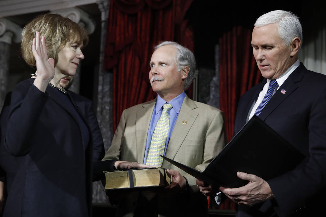 Vice President Mike Pence, right, administers the Senate oath of office during a mock swearing in ceremony in the Old Senate Chamber to Sen. Tina Smith, D-Minn., left, with her husband Archie Smit ...