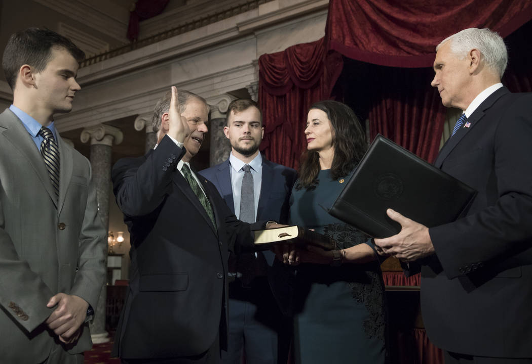 Vice President Mike Pence, right, administers the Senate oath of office during a mock swearing in ceremony in the Old Senate Chamber to Sen. Doug Jones, D-Ala., second from left, with his wife, Lo ...