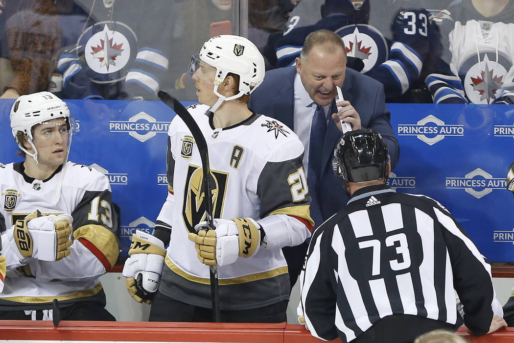 Las Vegas Golden Knights head coach Gerard, upper right, Gallant talks to a linesman (73) during first-period NHL hockey game action against the Winnipeg Jets in Winnipeg, Manitoba, Friday, Dec. 1 ...