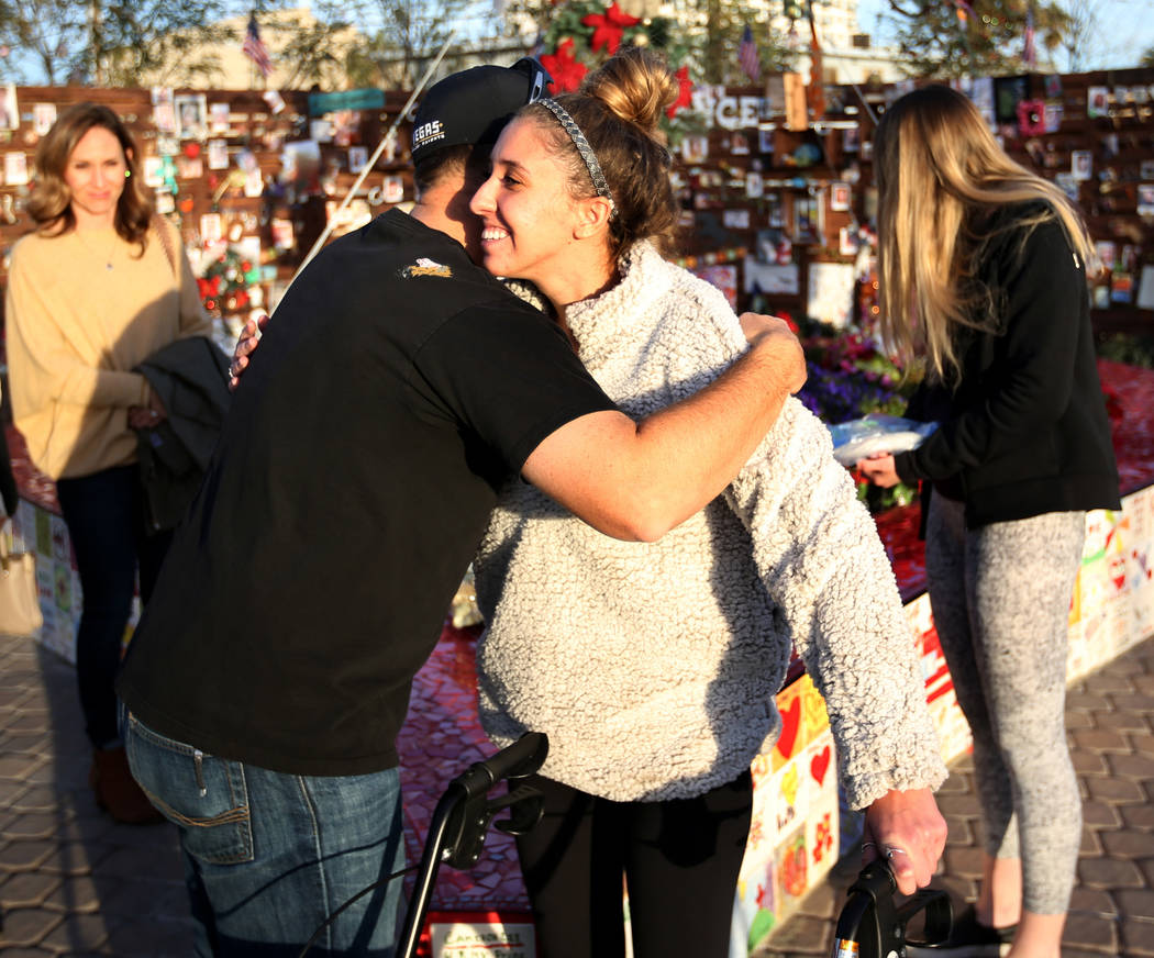 Katrina Hannah, 21, of La Verne, Calif., hugs Austin Stout, of Las Vegas, who carried her to safety after she was shot at the Route 91 Harvest festival during a visit to the Healing Garden in down ...
