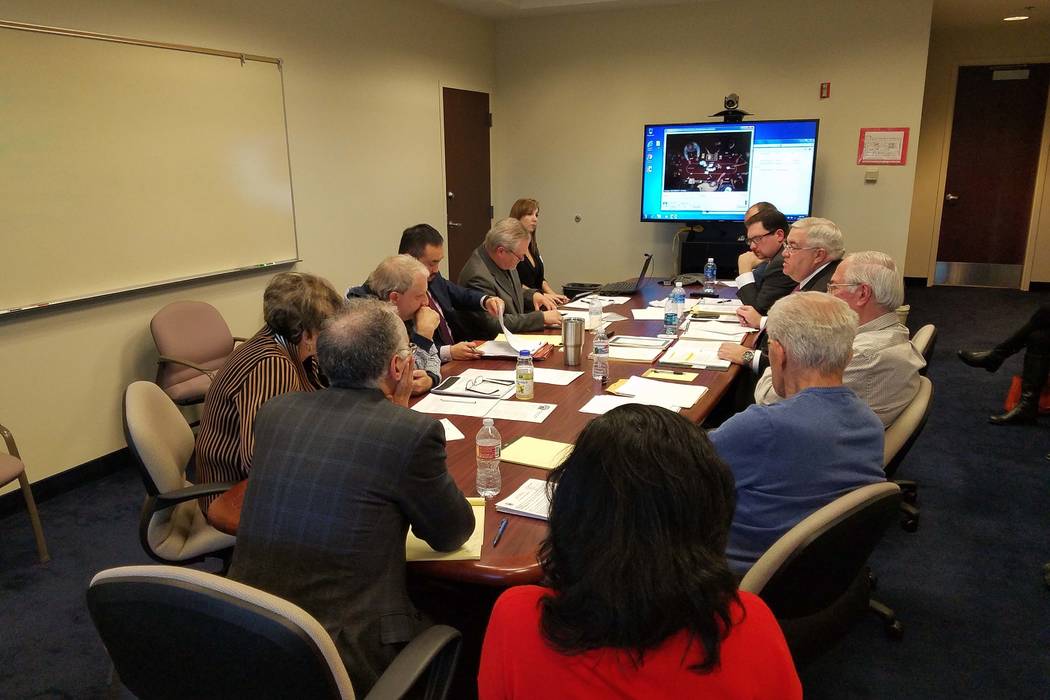 Poker players, Station Casinos' poker room officials and state Gaming Control Board administrators gather around a table in a conference room at the Gaming Control Board offices at the Sawyer Buil ...