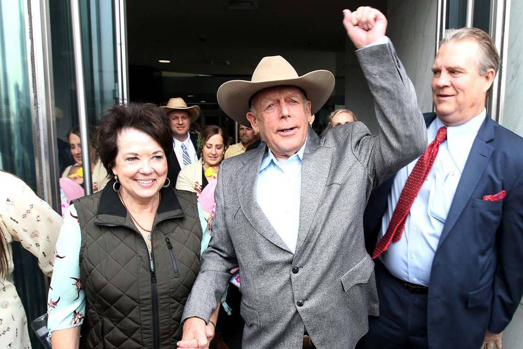 Cliven Bundy holds the hand of his wife, Carol, as he walks out of federal courthouse in Las Vegas for first time in nearly two years, Monday, Jan. 8, 2018. (Kevin Cannon/Las Vegas Review-Journal)