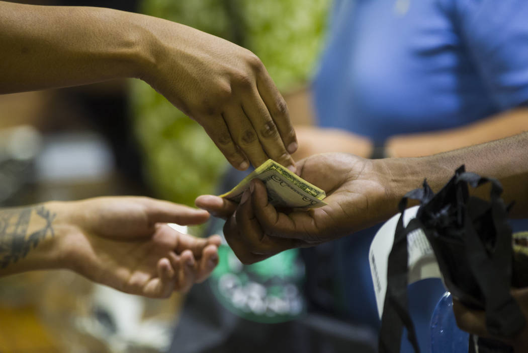 A customer receives change for a marijuana purchase as recreational sales become legal in Nevada at Reef Dispensaries in Las Vegas on Saturday, July 1, 2017. Chase Stevens Las Vegas Review-Journal ...