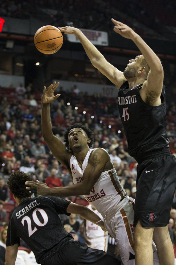 UNLV Rebels guard Jovan Mooring (30) shoots the ball against San Diego State Aztecs guard Jordan Schakel (20) and center Kameron Rooks (45) at the Thomas & Mack Center in Las Vegas, Saturday, ...