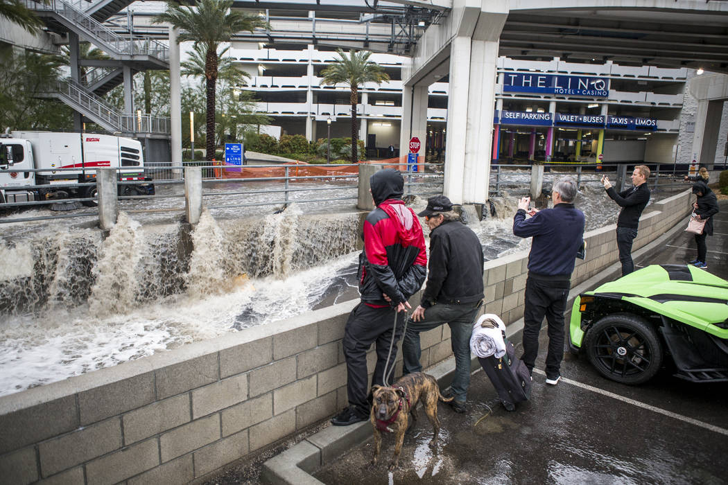 People watch flood waters rush by in a flood channel near The Linq Hotel in Las Vegas on Tuesday, Jan. 9, 2018. Patrick Connolly Las Vegas Review-Journal @PConnPie