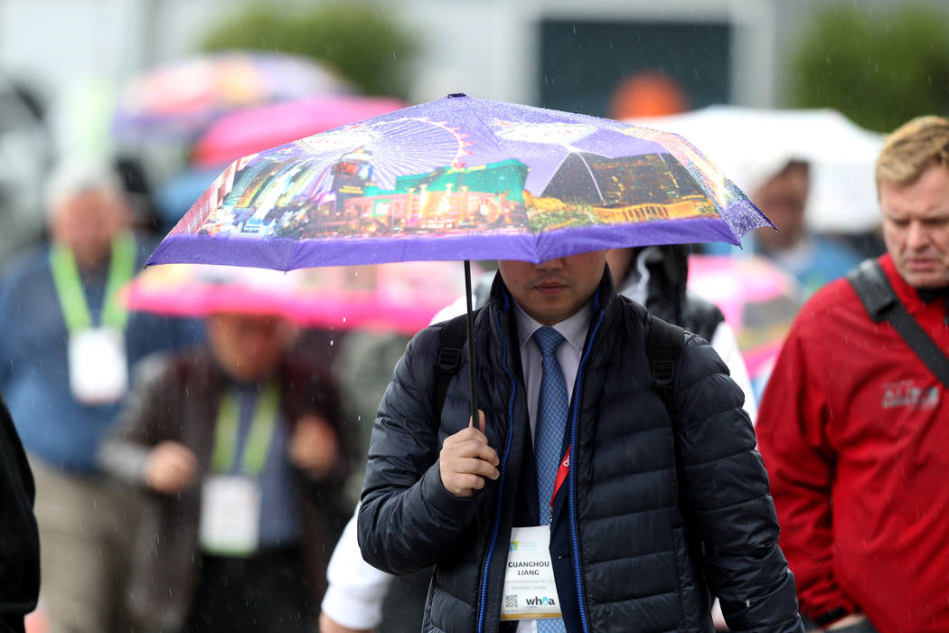 Attendees cross Paradise Road to CES at the Las Vegas Convention Center during a rain storm on Tuesday, Jan. 10, 2018. (K.M. Cannon/Las Vegas Review-Journal) @KMCannonPhoto
