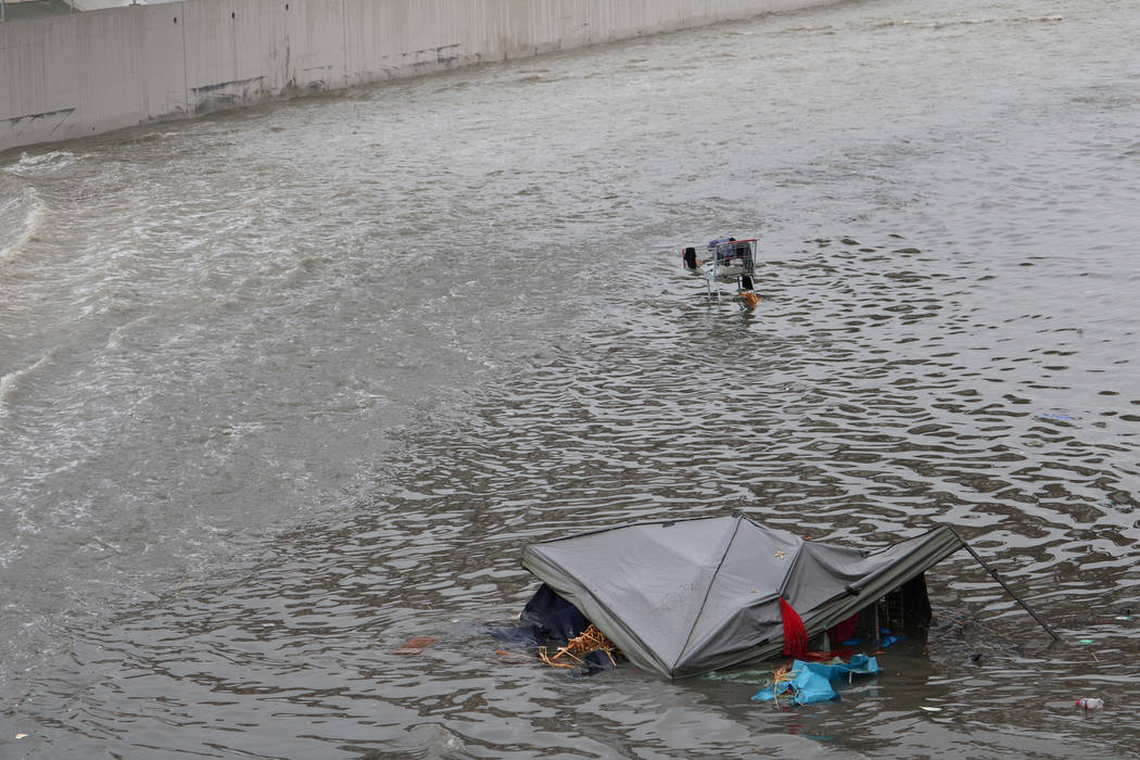 A tent and a shopping cart are caught in floodwaters above a detention basin near east Cheyenne Avenue along the Las Vegas Wash on Tuesday, Jan. 9, 2018. About a mile downstream, rescue crews came ...