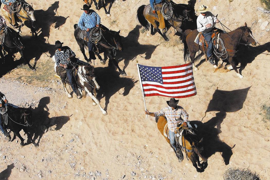 FILE - In this April 12, 2014, file photo, the Bundy family and their supporters fly the American flag as their cattle is released by the Bureau of Land Management back onto public land outside of ...