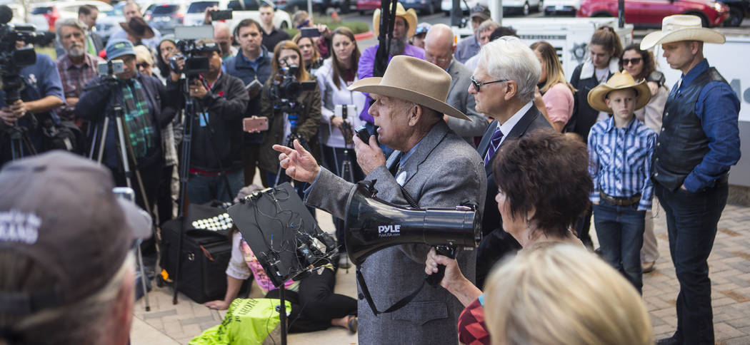 Rancher Cliven Bundy, center, address supporters and journalists at Metropolitan Police Department headquarters two days after federal charges were dismissed against him in Las Vegas on Wednesday, ...