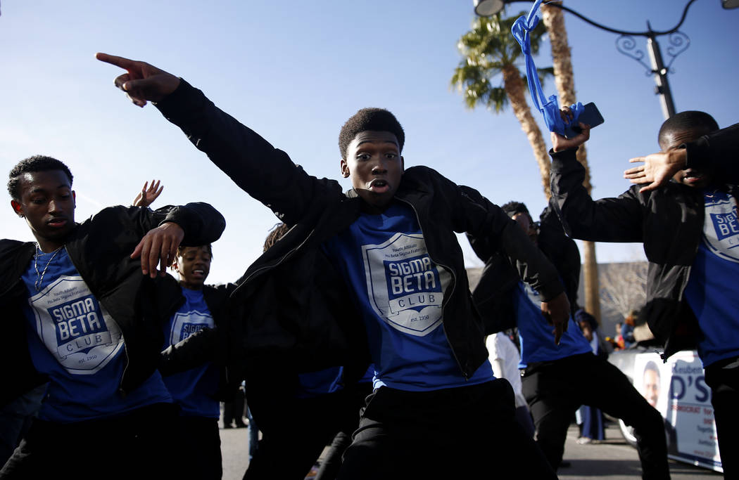 Thomas Salsberry, a 17-year-old Sigma Beta Club member, dances along with teammates during the 36th annual Dr. Martin Luther King Jr. Parade, themed "Living the Dream: Building a Bridge to Unity"  ...
