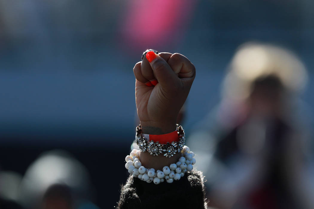 An attendee raises her fist during the Power to the Polls event, hosted by the Women's March, at the Sam Boyd Stadium in Las Vegas, Jan. 21, 2018. The event, which served as an advocacy tool to re ...