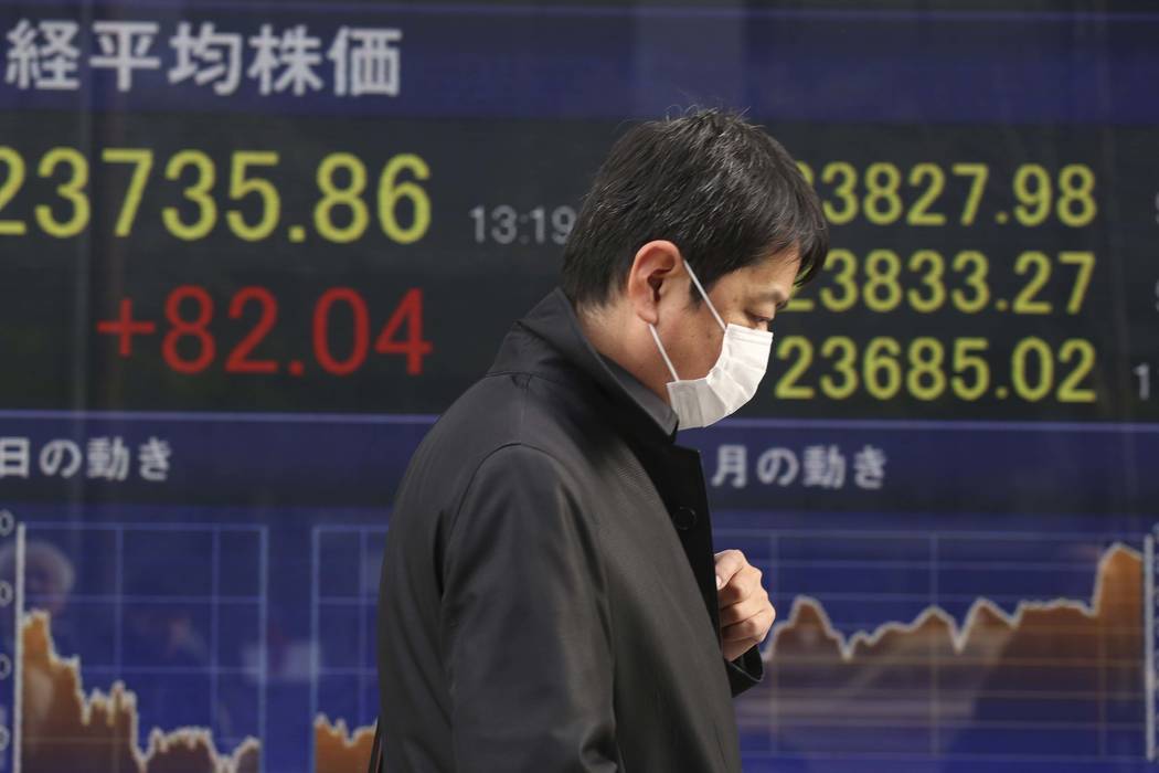 A man walks by an electronic stock board of a securities firm in Tokyo, Monday, Jan. 15, 2018. Asian stock markets edged higher on Monday after Wall Street's strong finish last week. The U.S. doll ...