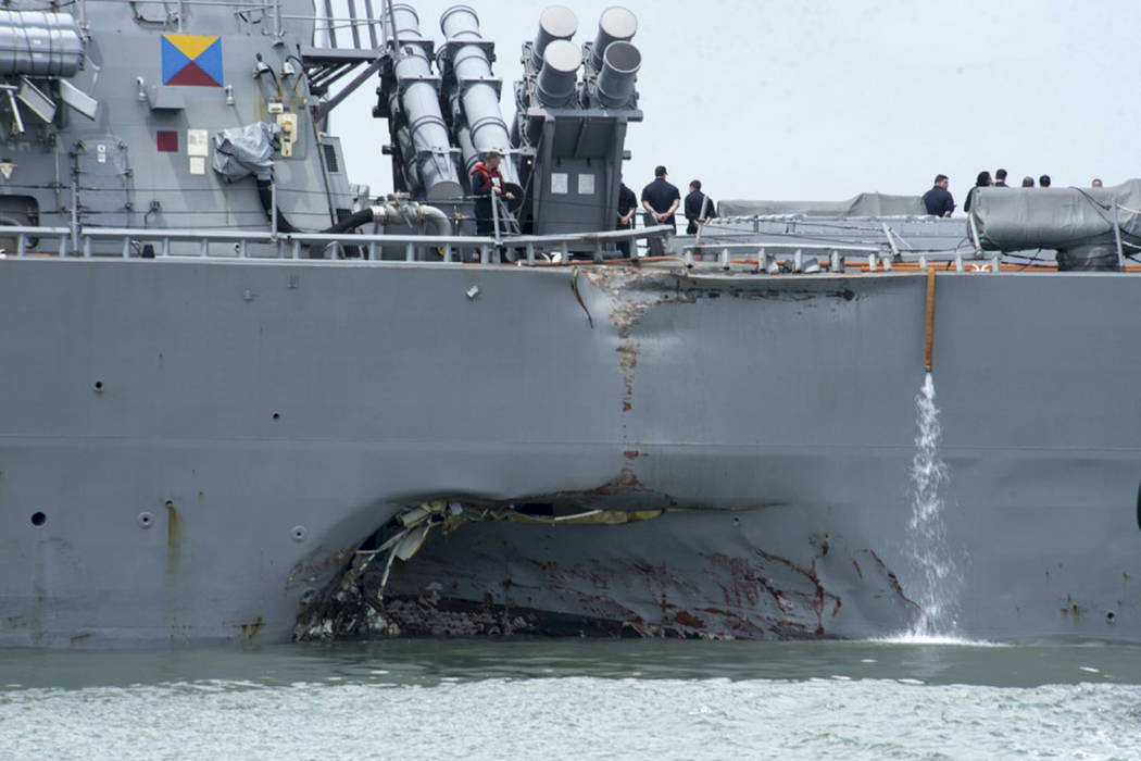 In this Aug. 21, 2017, file photo, provided by the U.S. Navy, damage is visible as the guided-missile destroyer USS John S. McCain steers towards Changi naval base in Singapore following a collisi ...