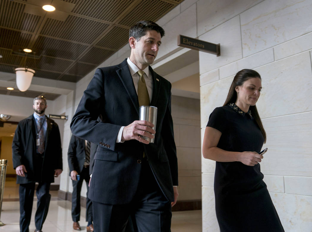 House Speaker Paul Ryan of Wis., center, accompanied by his Press Secretary AshLee Strong, right, walks to the Capitol Building from the Capitol Visitor's Center, Thursday, Jan. 18, 2018, in Washi ...