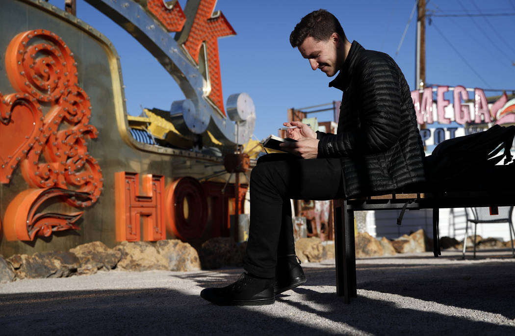 In this Jan. 23, 2018, photo, digital artist and designer Craig Winslow looks at his notebook at an exhibit at the Neon Museum in Las Vegas. Starting this week, visitors will be able to see many o ...