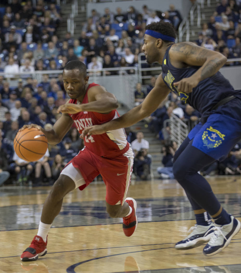 UNLV's Jordan Johnson drives past Nevada's Jordan Caroline during the first half of an NCAA college basketball game in Reno, Nev., Wednesday, Feb. 7, 2018. (AP Photo/Tom R. Smedes)