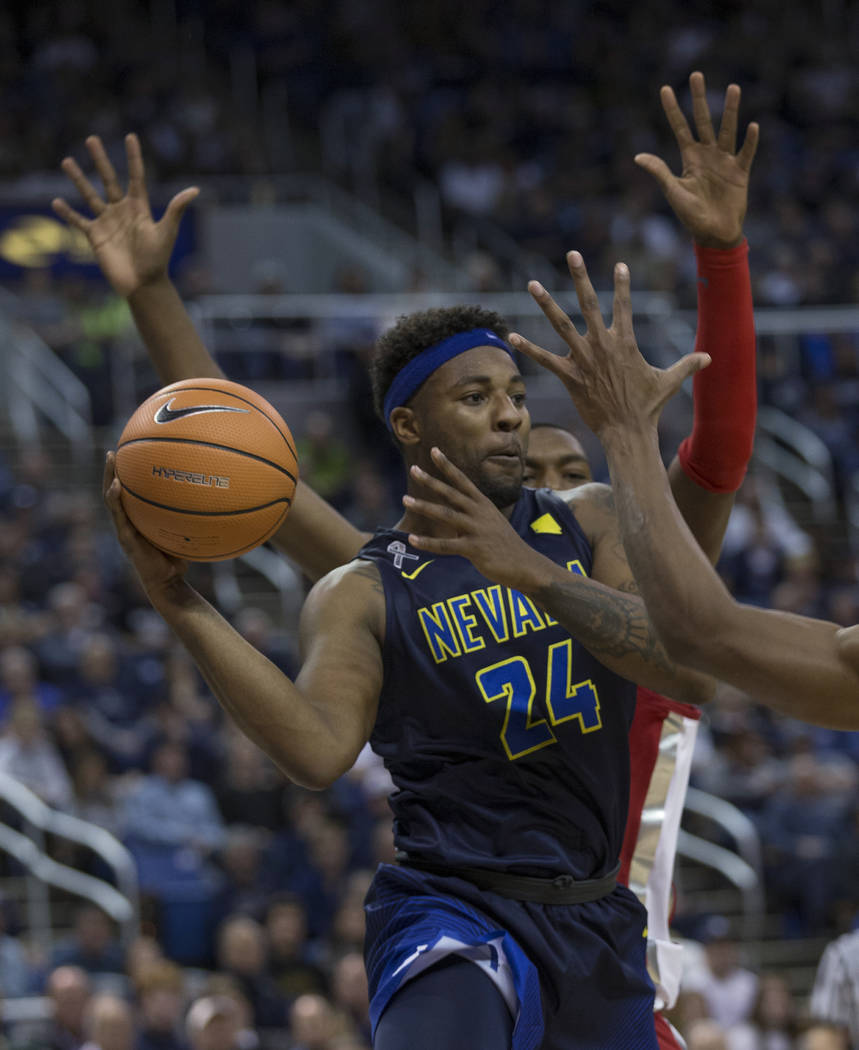 Nevada Jordan Caroline looks to pass the ball against UNLV during the first half of an NCAA college basketball game in Reno, Nev., Wednesday, Feb. 7, 2018. (AP Photo/Tom R. Smedes)