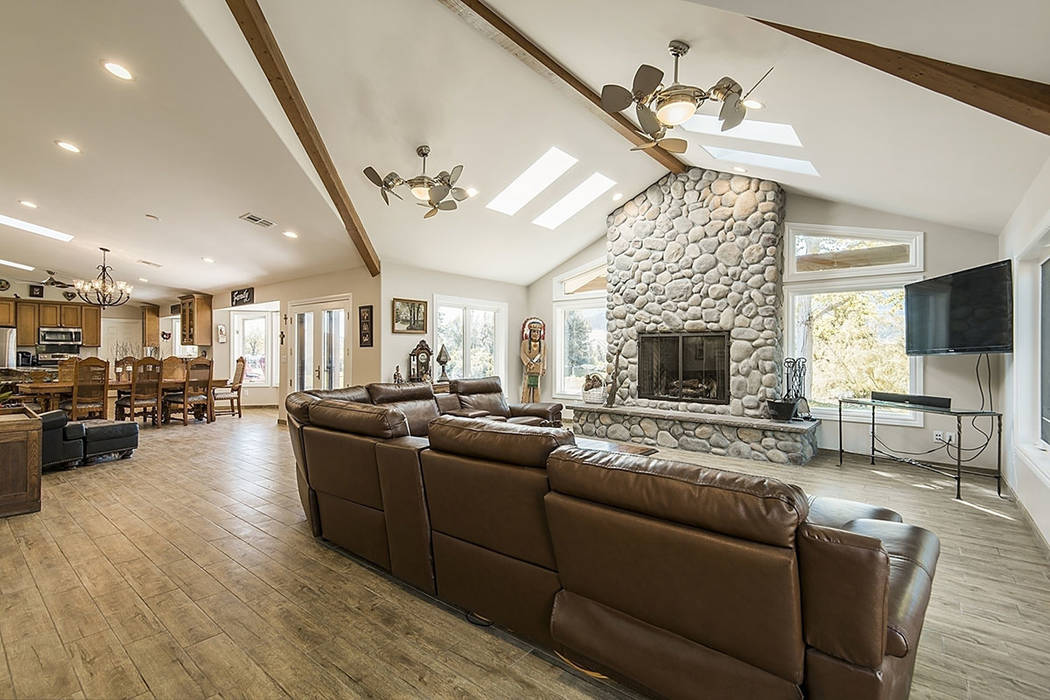 The family room has high, wood-beamed ceiling, skylights and a river rock fireplace. (Realty One Group)