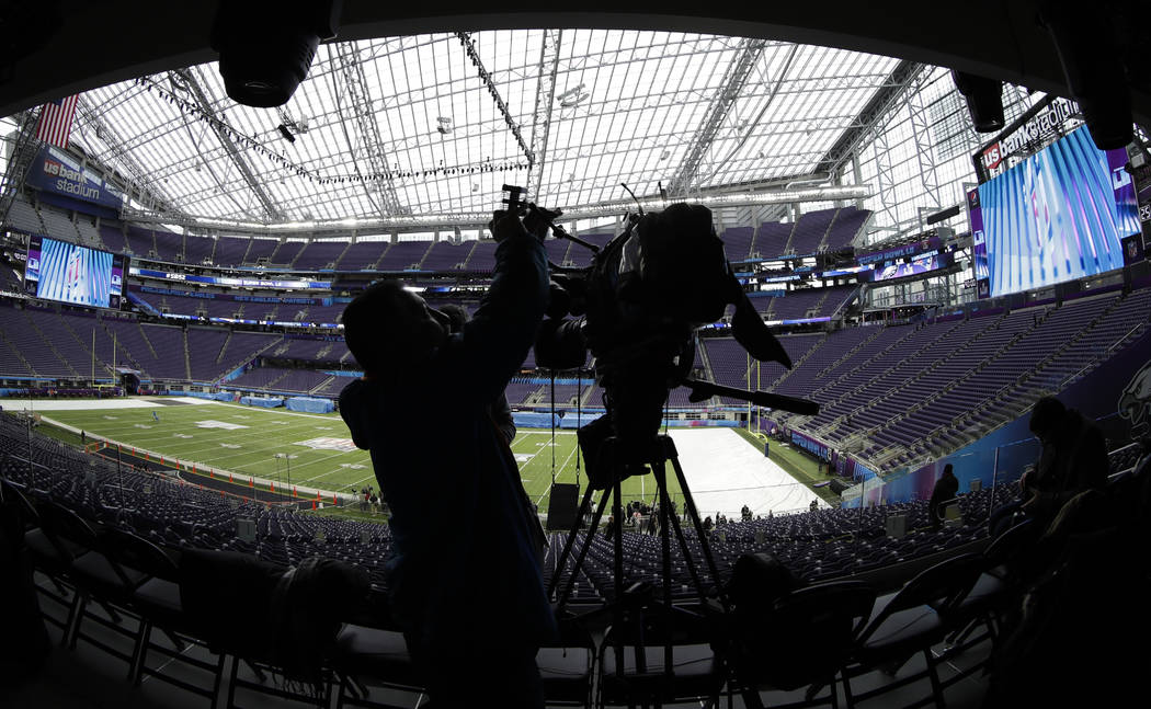 A videographer shoots video of U.S. Bank Stadium as workers get it ready for Super Bowl 52 on Tuesday, Jan. 30, 2018, in Minneapolis. (AP Photo/Matt Slocum)