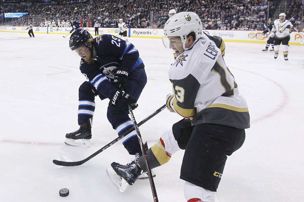 Winnipeg Jets' Patrik Laine (29) and Vegas Golden Knights' Brendan Leipsic (13) fight for possession of the puck during the second period of an NHL hockey game Thursday, Feb. 1, 2018, in Winnipeg, ...